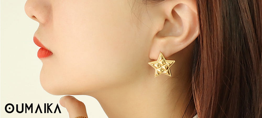 Minimalist gold star earrings on white background