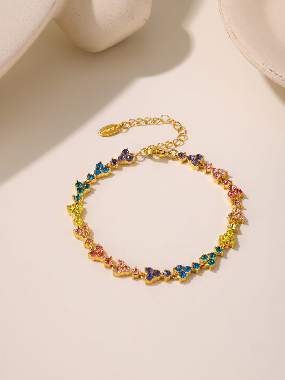 A TXE215 multicolored zircon bracelet in gold tone displayed in a stylish setting.