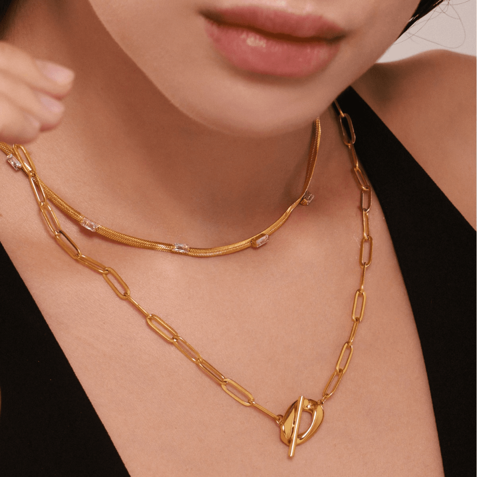 Layered jewelry look with Oudada gold blade chain and other delicate chains, 2024 trend inspiration