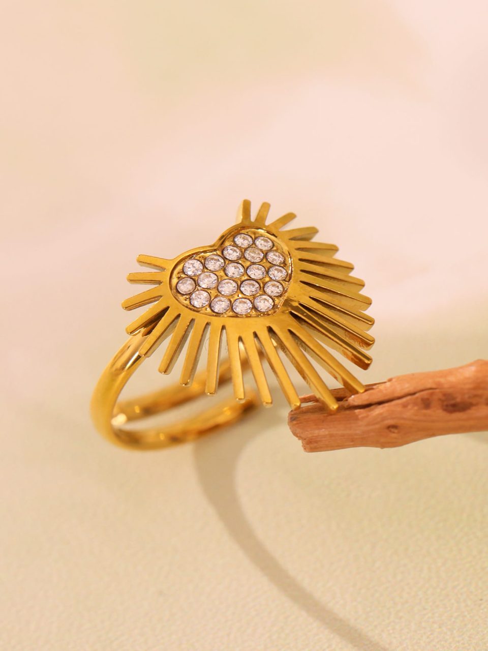 A gold Winged Heart Open Ring with sparkling Cubic Zirconia, placed in a stylish scene, exuding luxury and fashion.
