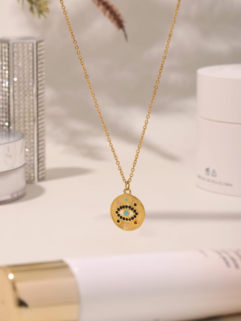 Flat lay of white cubic zirconia eye pendant necklace on marble - minimalist symbolic jewelry product shot