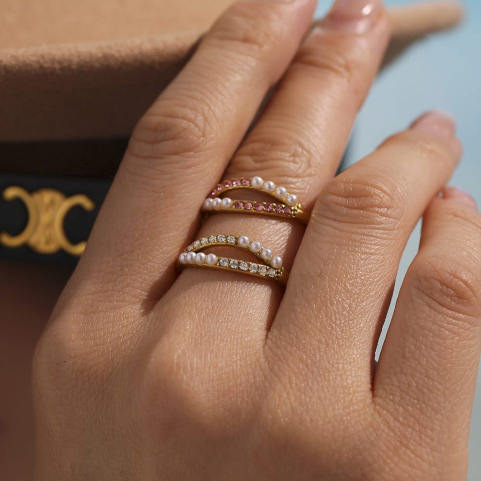 model wearing hat and gold adjustable statement ring with pink pearls and cubic zirconia