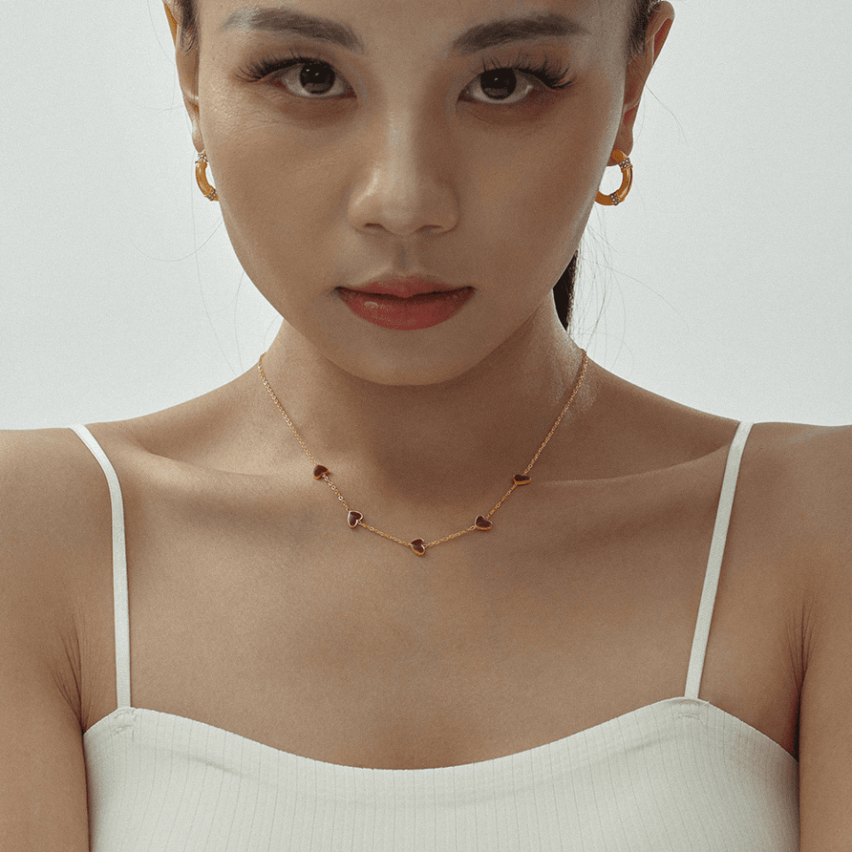 Stylish woman wearing Oudada enamel heart necklace with V-neck top - day to night transitional jewelry styling