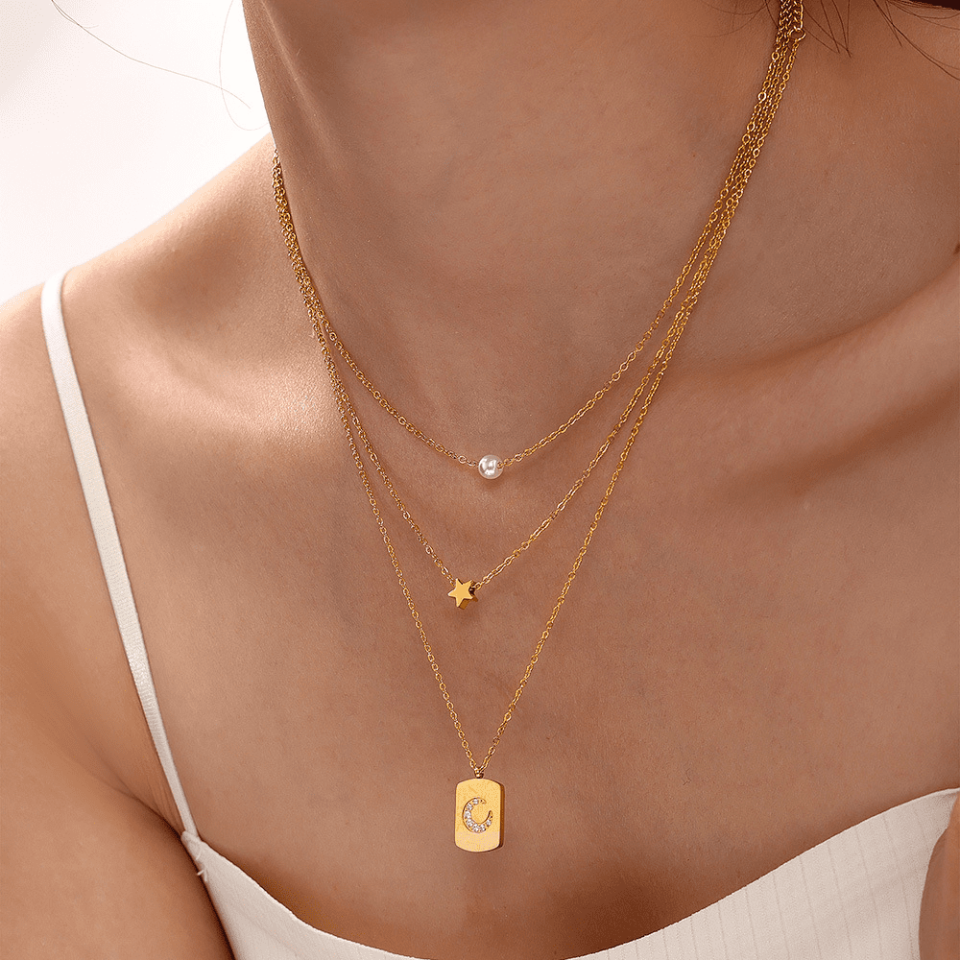 Stylish woman wearing Oudada layered necklace with white blouse - office to evening transition styling