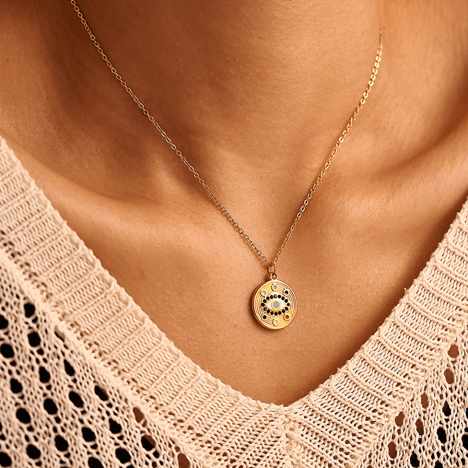 Stylish woman wearing gold Talisman Eye necklace with white V-neck top - everyday light luxury jewelry styling
