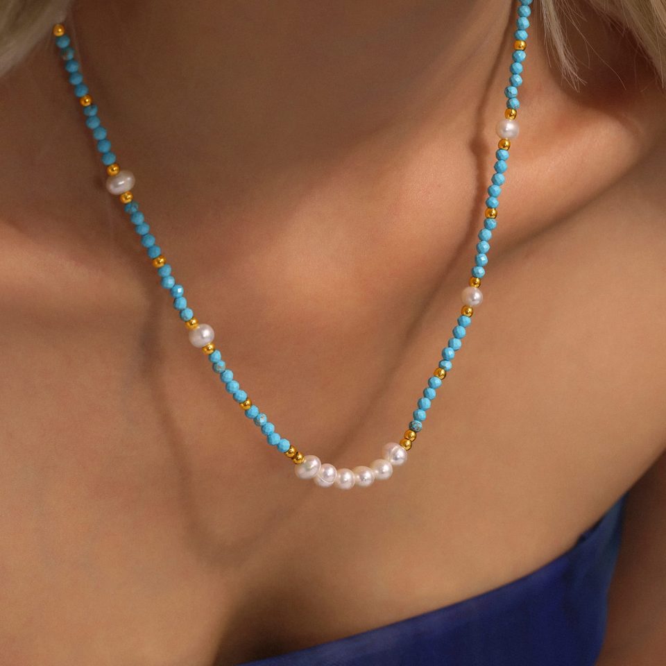 A model showcasing the TXP229 turquoise and pearl necklace paired with a matching bracelet, creating a cohesive and stylish ensemble.