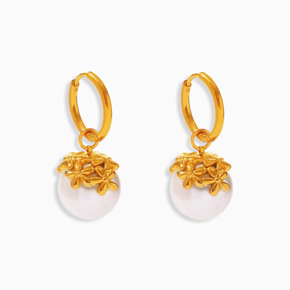 Mini gold flower pearl drop earrings with white shell pearls on a white background