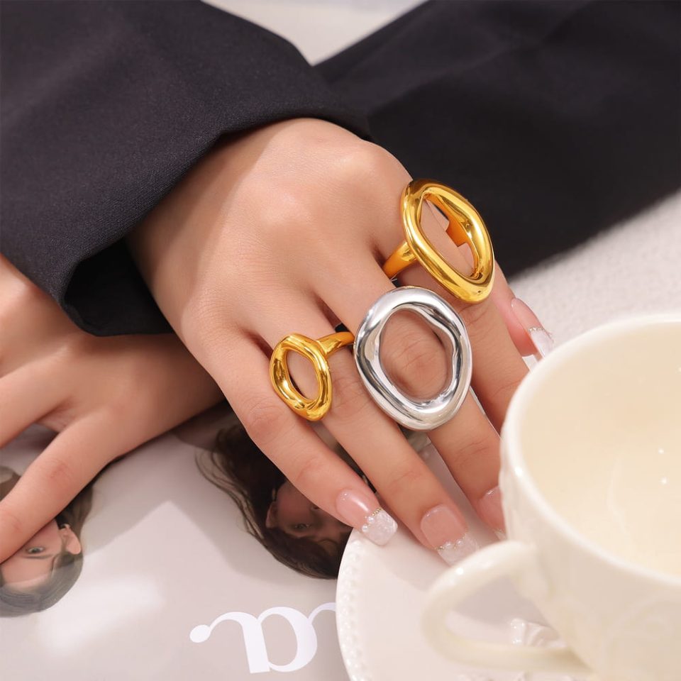 Model wearing both stainless steel and gold A641 geometric rings, crossed hands styling