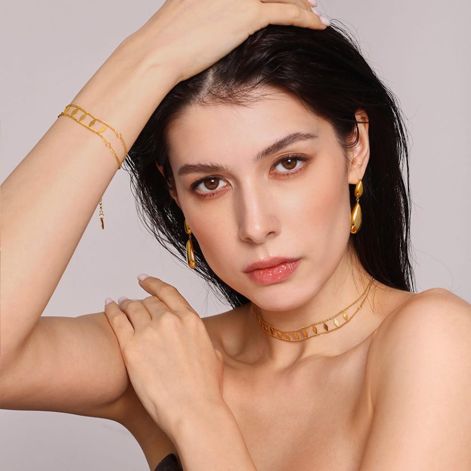 Close‑up of Geometric Glitter Double‑Layer Choker gold‑tone stainless steel necklace on model’s hand