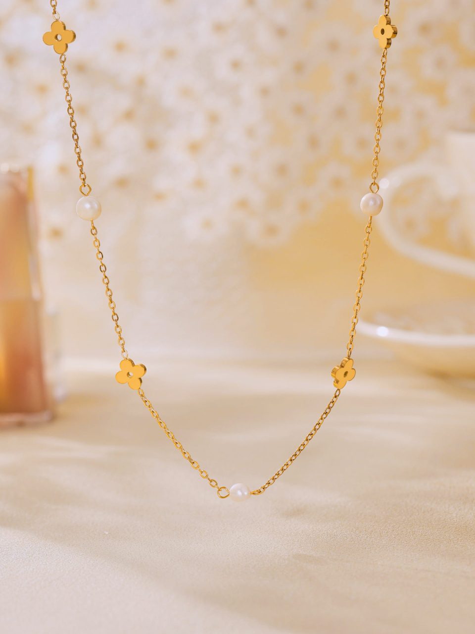 Women’s pearl floral choker necklace styled under warm ambient lighting.