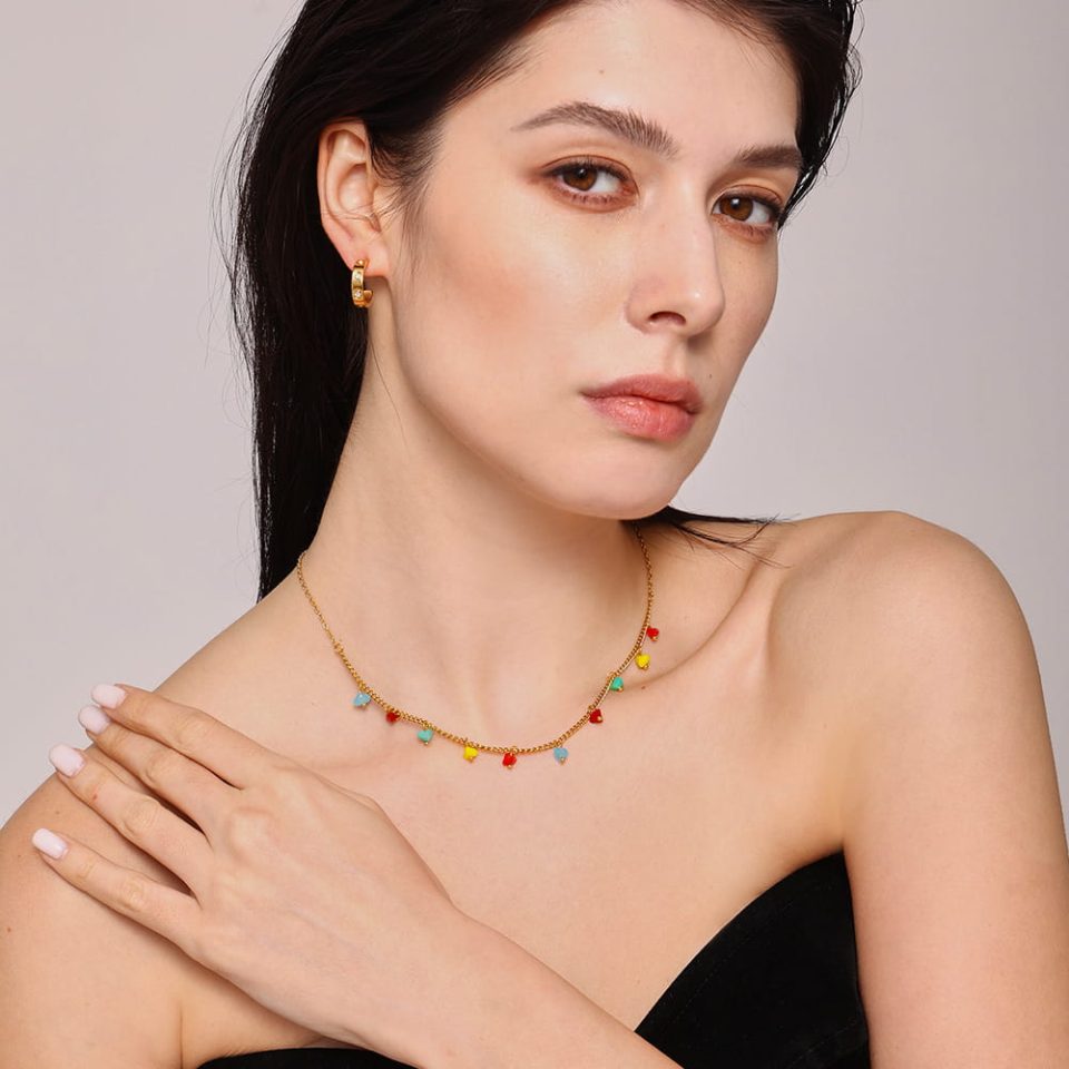 Model gazing down wearing boho faceted crystal choker necklace showcasing drape