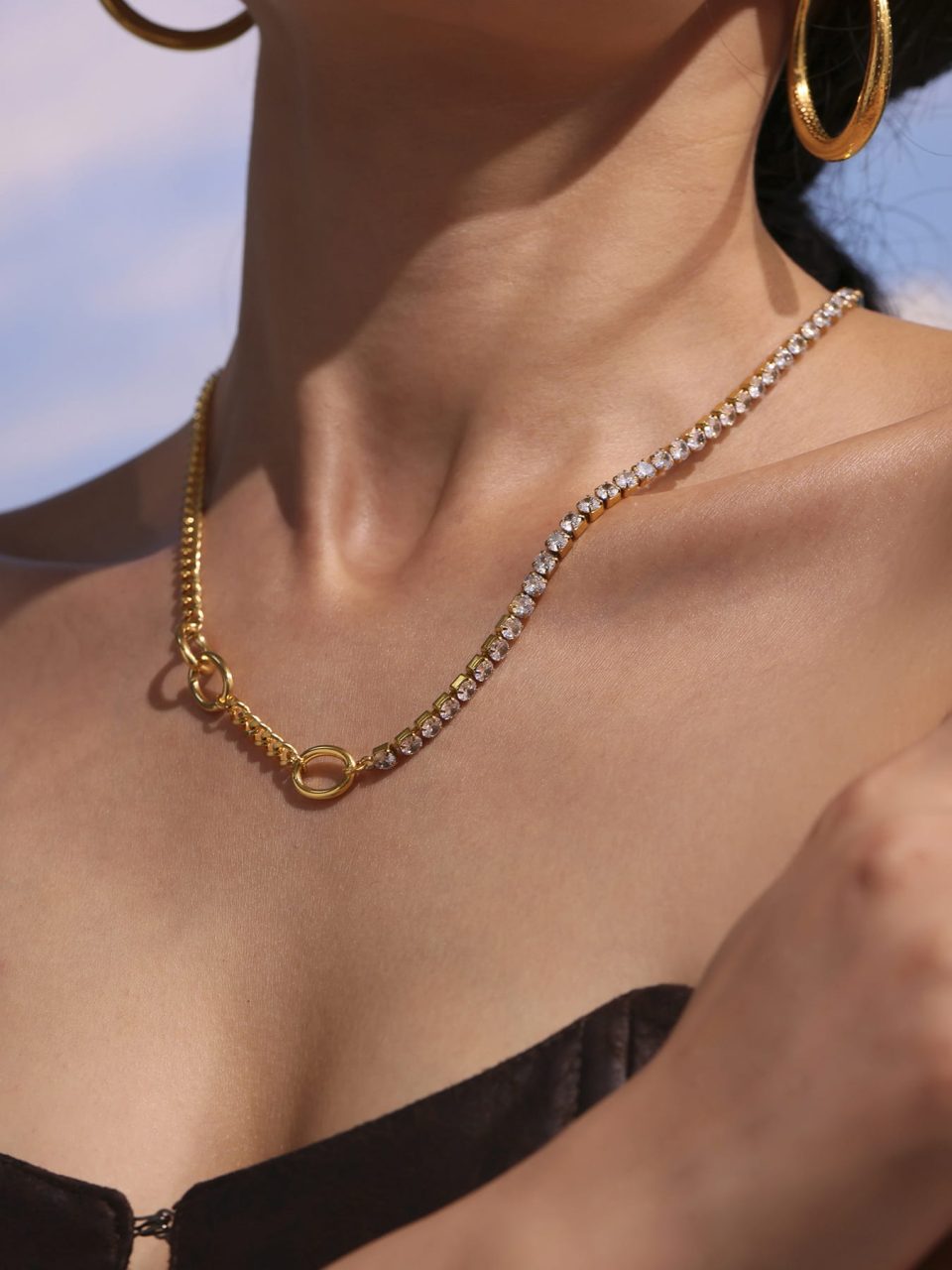 Model wearing dainty zircon choker necklace, left side profile with gold sparkle chain