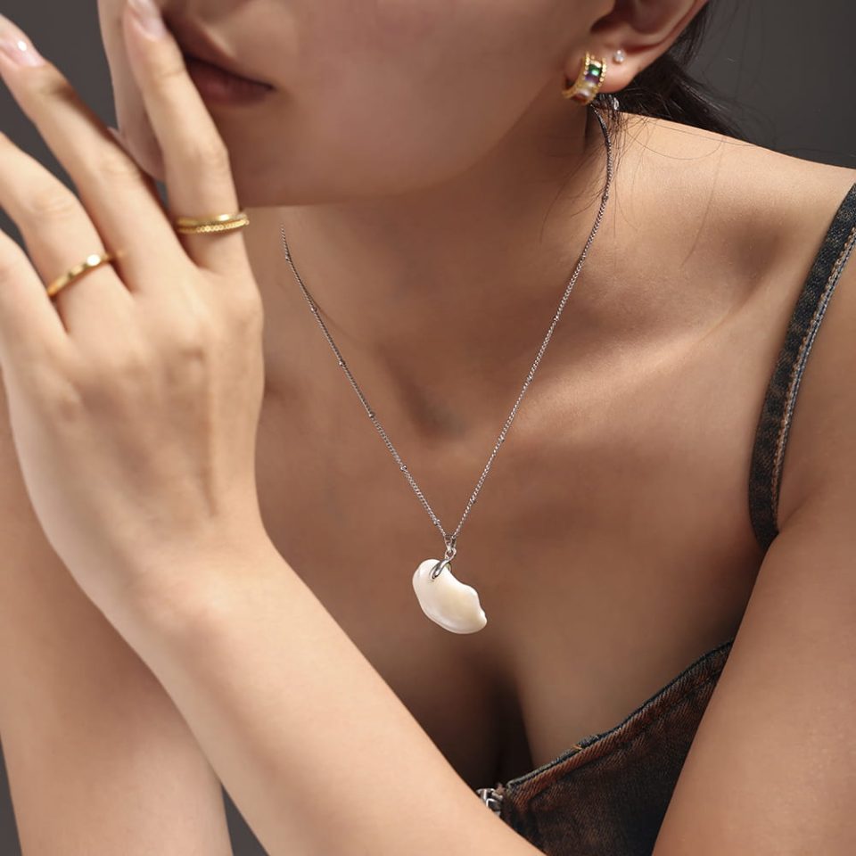 Model wearing a shell pendant necklace P2094