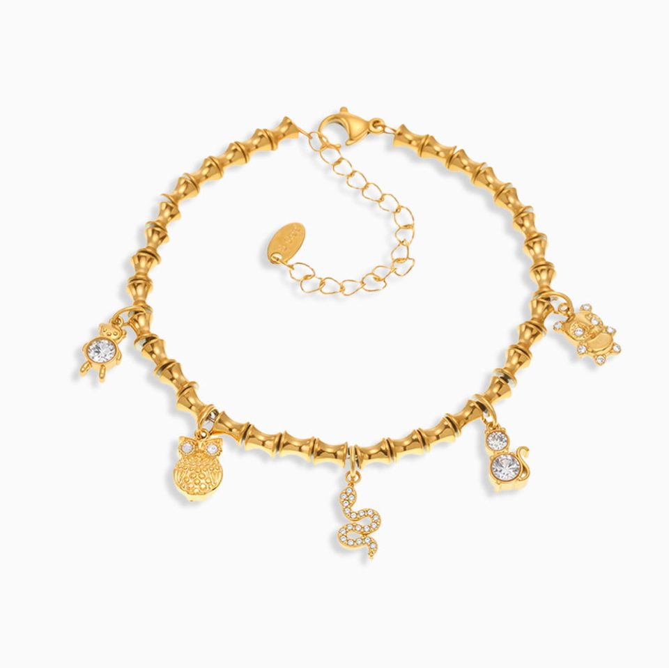 Gold bamboo link bracelet with cubic zirconia charm, waterproof stainless steel design on white background