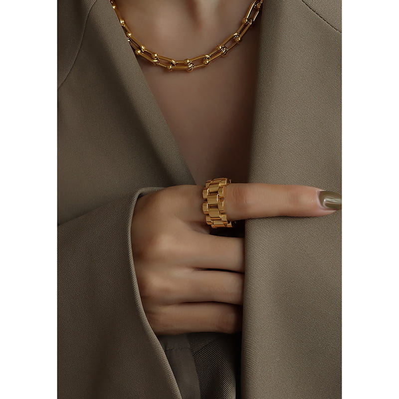 Fashion model in green suit wearing chunky gold ring on index finger