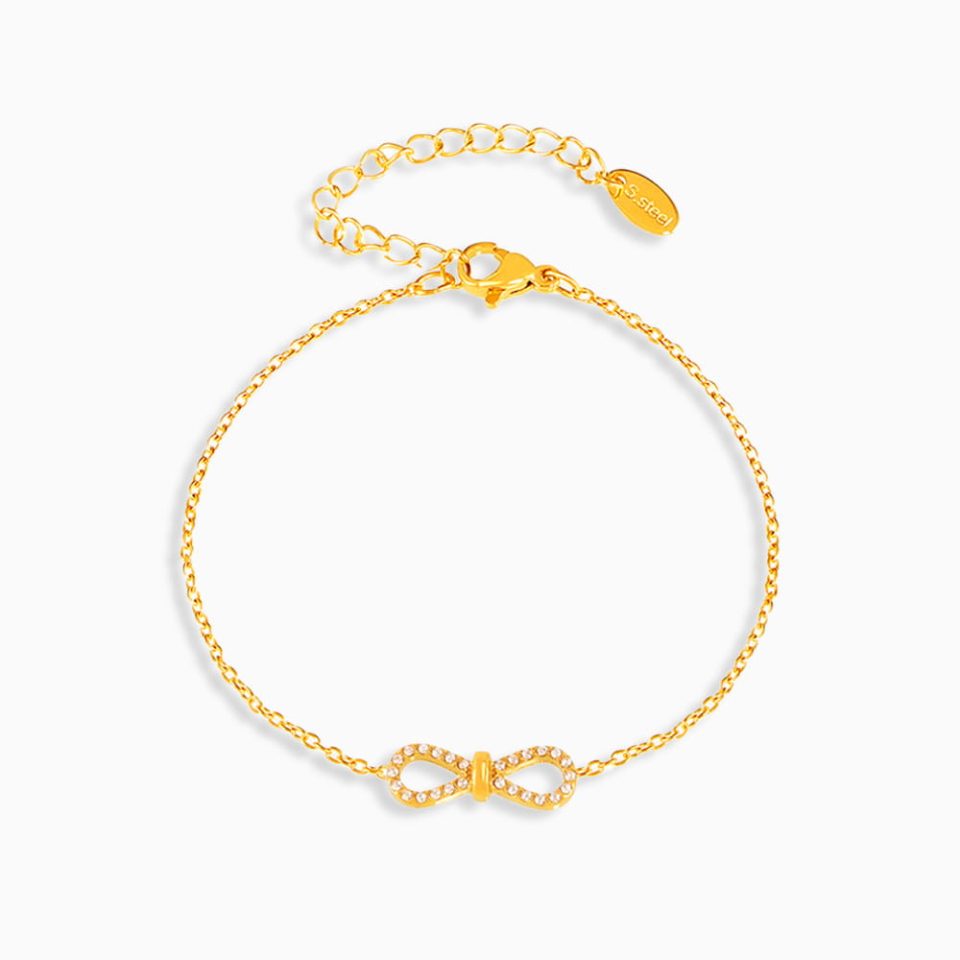 Gold infinity symbol bracelet with cubic zirconia on white background