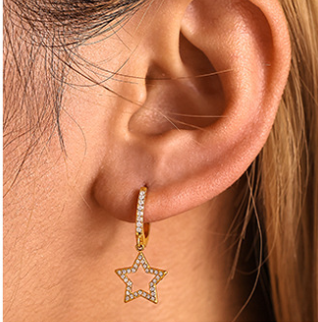Woman wearing gold cubic zirconia drop earrings with star design