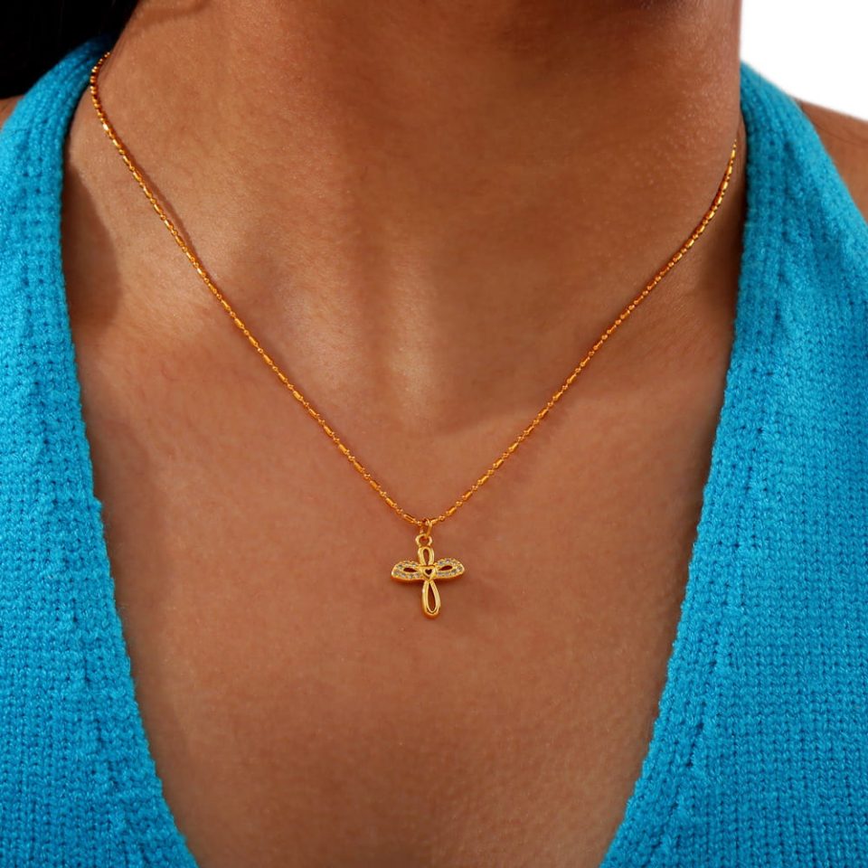 Woman wearing winged heart stainless steel necklace with zirconia detail
