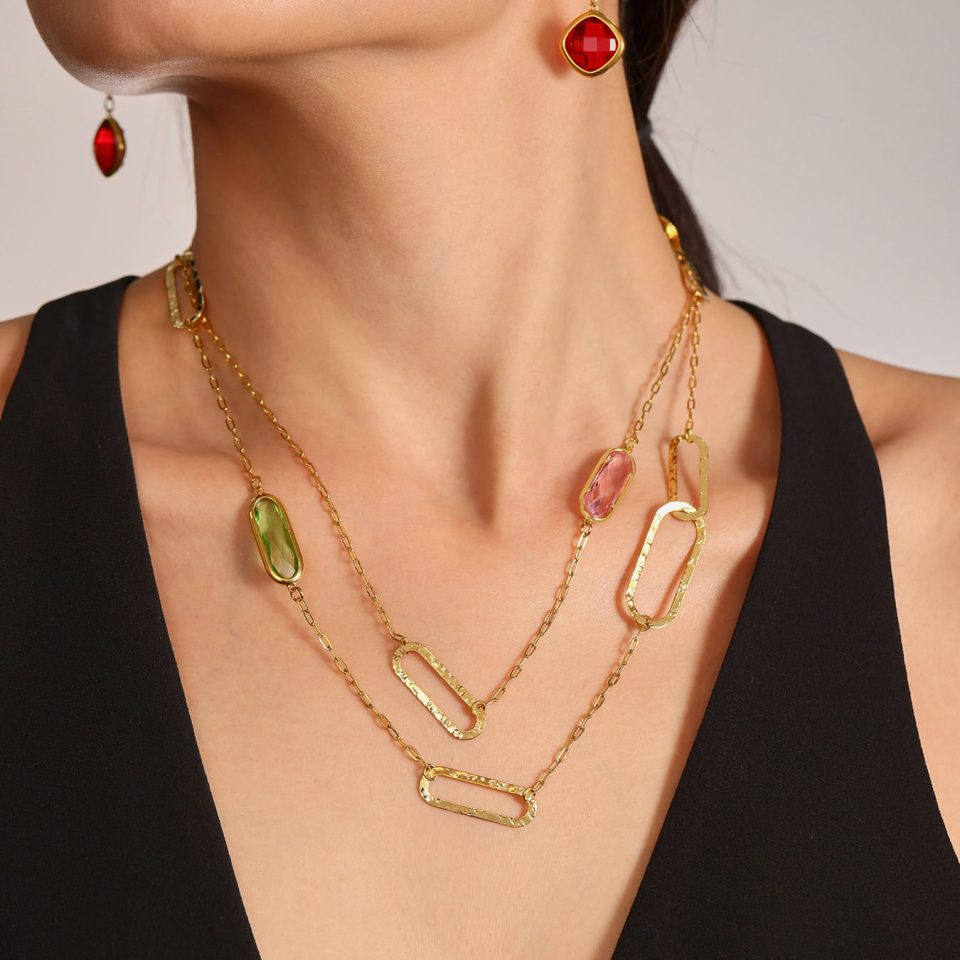 Model wearing pink, green, and red faceted sea glass necklaces layered over a casual outfit