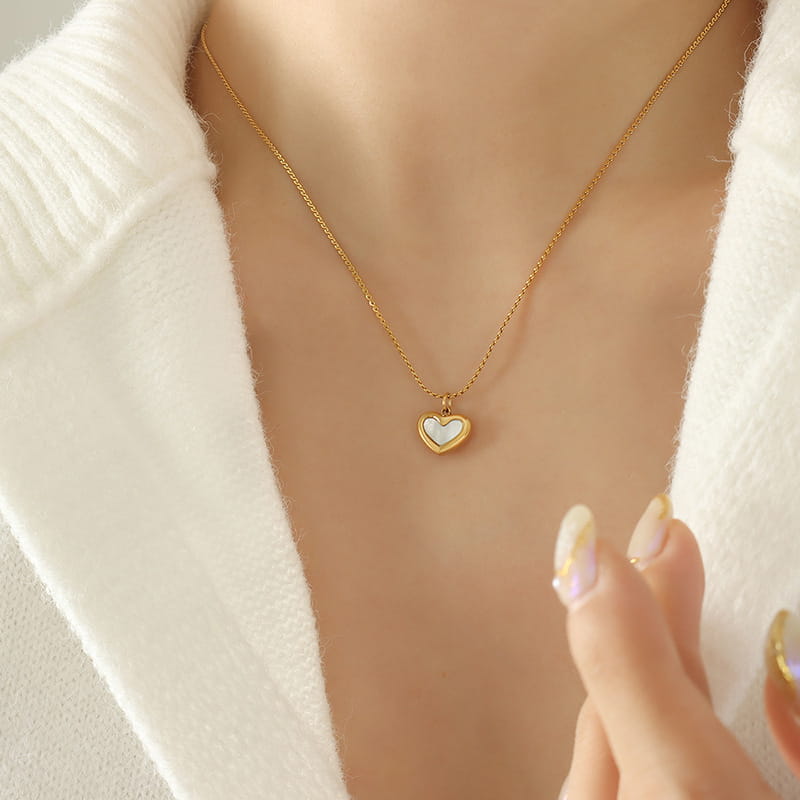 Model wearing a gold shell heart necklace p629