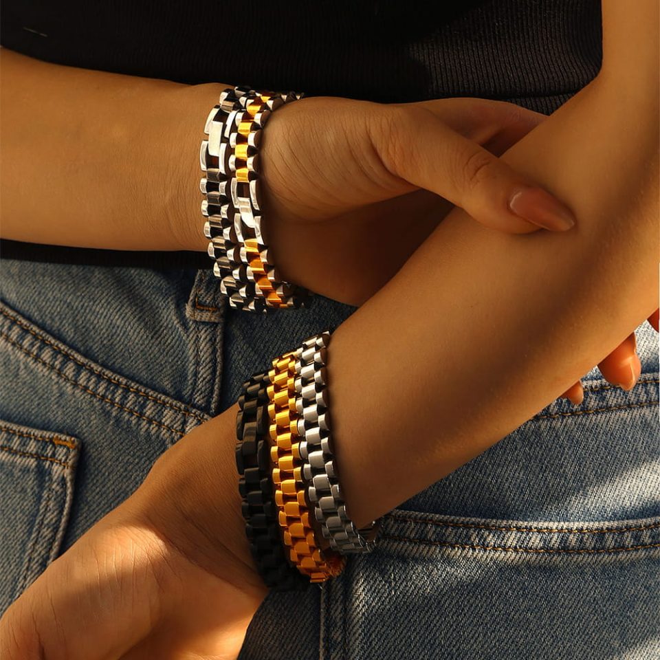 the model is wearing a thick golden bracelet