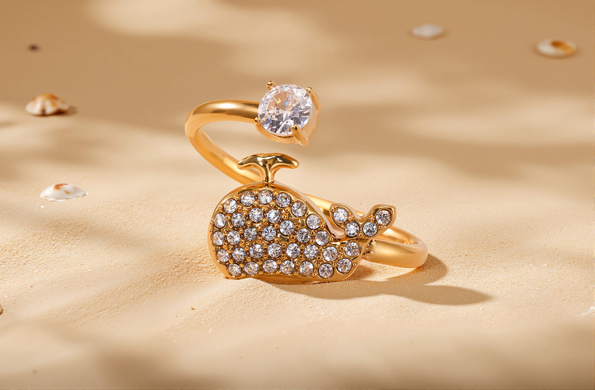 Gold whale-shaped open ring with cubic zirconia on sandy beach