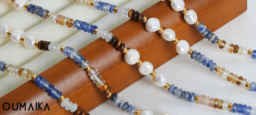 Flat lay of layered stainless steel necklaces under soft lighting