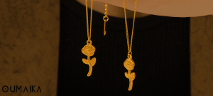 Opened satin-lined jewelry box with stainless steel flower necklace inside, featuring OumaiKa branded dust pouch
