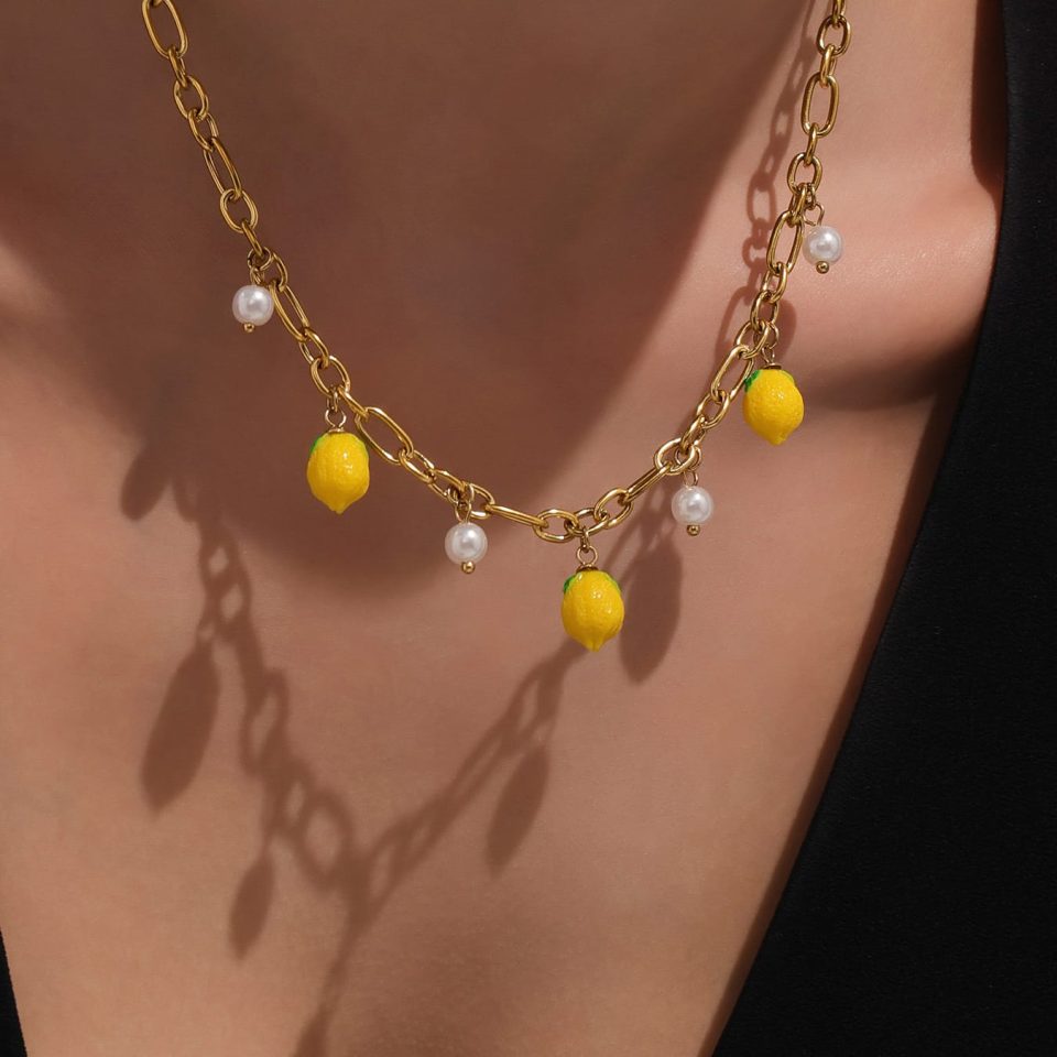 Close-up of gold bead necklace with lemon resin and shell pendant on model