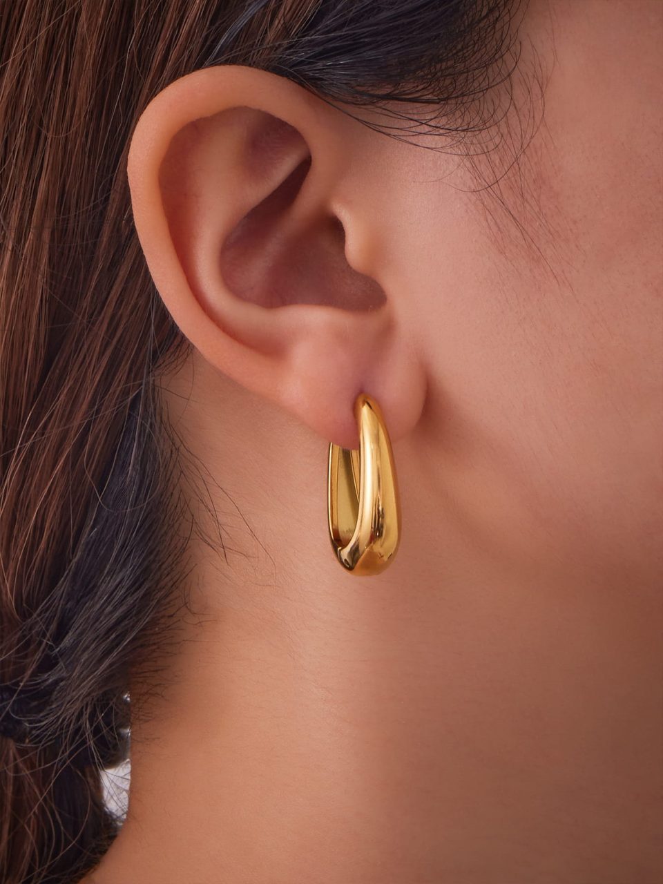 Model wearing gold U-shaped earrings F583-