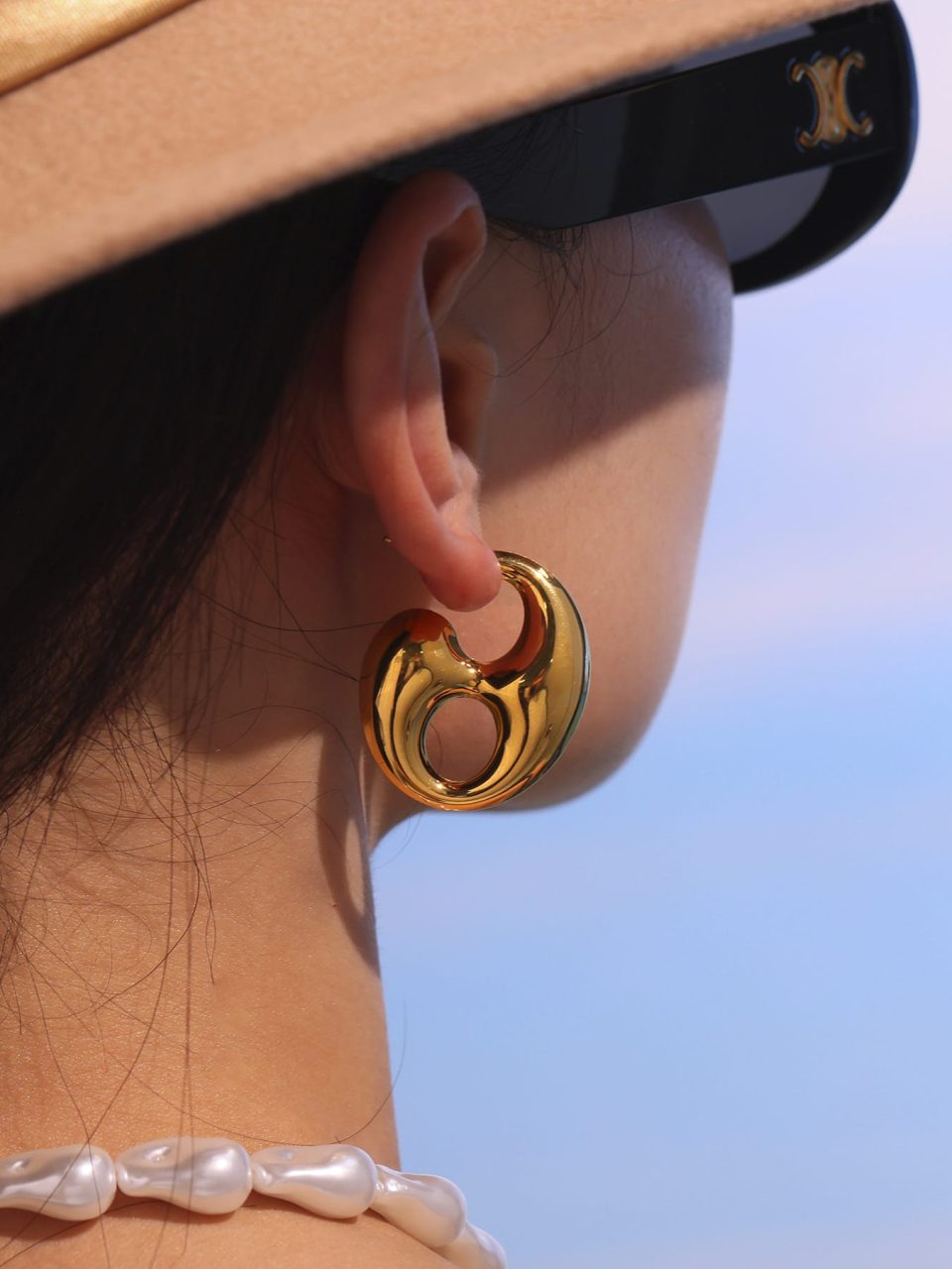 Model wearing gold coffee bean hollow earrings F272-