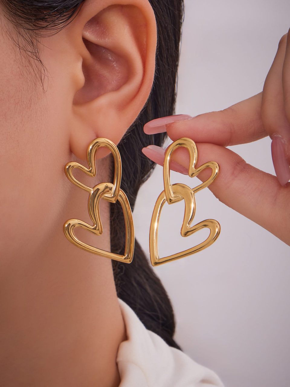Model Wearing Gold Stainless Steel Double Heart Hoop Earrings F557