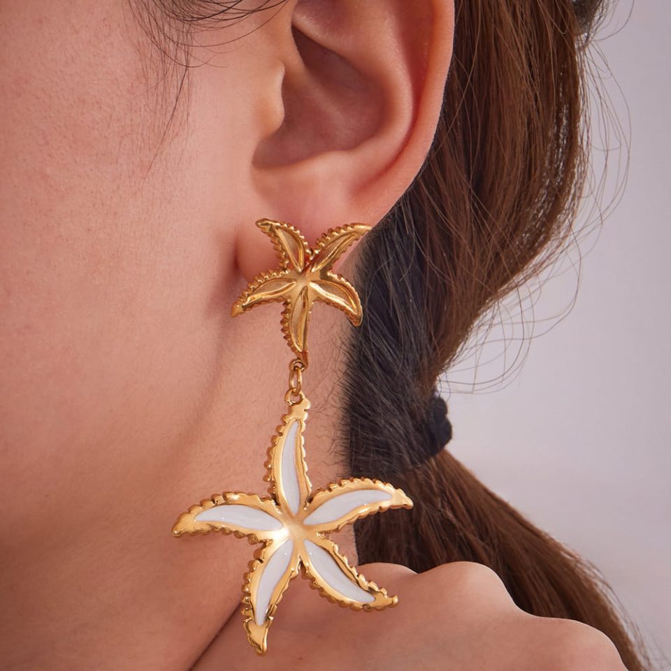 Model wearing gold starfish dangle earrings stainless steel jewelry