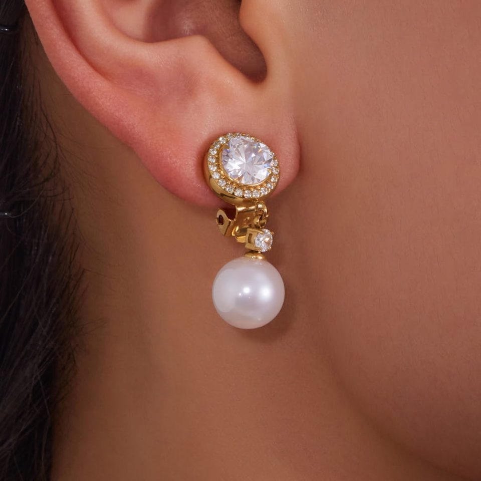 Model wearing gold zircon faux pearl drop ear cuff on hand for fashion styling