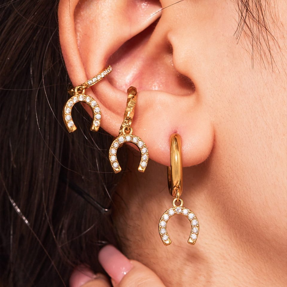 Model wears gold horseshoe buckle zircon U-shaped earrings Q057