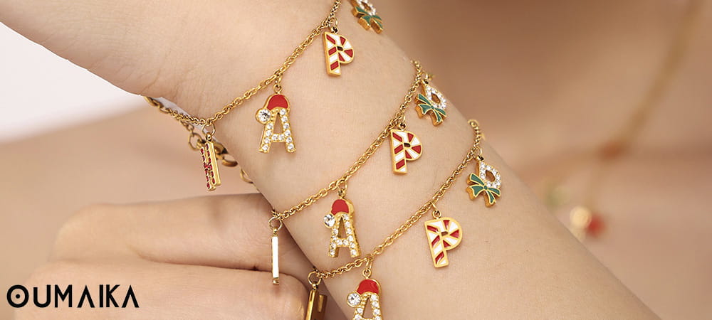 Gold-plated Christmas charm bracelets with candy cane and Santa hat charms from Oumaika Jewelry.