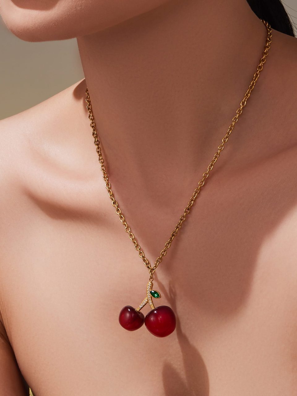 Model wearing Oumaika’s cherry resin pendant necklace with red resin cherries, minimalist stainless steel jewelry for daily wear.